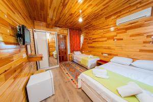 契拉勒伊吉兹简易别墅假日公园的卧室配有木墙内的两张床