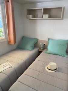 瓦尔拉普拉日Mobil Home 3 chambres climatisé tout équipé的一间设有两张床的房间,上面有一顶帽子
