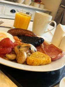 惠特比Smugglers Rest Bed & Breakfast的桌上的早餐食品和橙汁