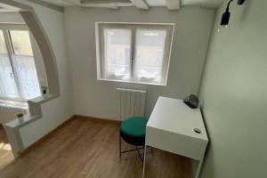 拉瓦勒Centre-ville : Maison de charme - Secteur calme的客房配有书桌和绿椅。