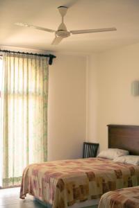 埃斯孔迪多港Hotel Caracol Plaza的一间卧室配有两张床和吊扇