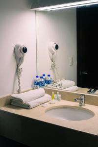 埃斯孔迪多港Hotel Caracol Plaza的一间带水槽和大镜子的浴室
