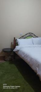 奈瓦沙Annettes Place的卧室配有带白色枕头和桌子的床