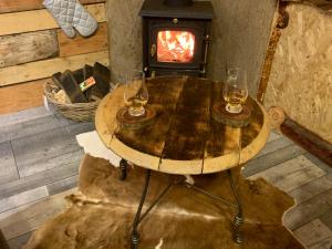 阿伯劳尔The Bothy Aberlour的木桌旁的两杯葡萄酒,配有燃木炉