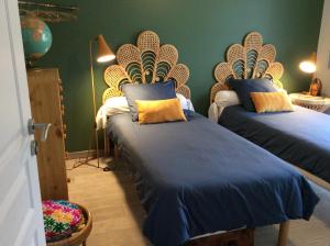 鲁埃格自由城Le Cottage des Mésanges的一间卧室配有两张带蓝色和黄色枕头的床
