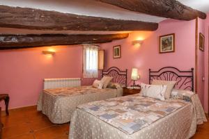 贝塞特洛费雷乡村民宿的一间卧室设有两张床,墙壁粉红色