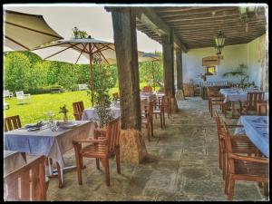 Toñanes拍拉兹恩德拖南尼斯酒店的一间带桌椅和遮阳伞的餐厅