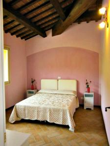 韦鲁基奥Brigida的卧室配有一张粉红色墙壁上的床铺