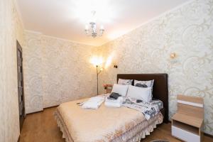 阿斯塔纳В Promenade Expo квартира с романтическим видом的壁纸客房内的一间卧室配有一张床