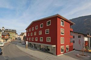 迪森蒂斯3,5 Zimmer Dachwohnung: Modern, komfortabel, zentral, mit Bergsicht的街道边的红色建筑