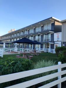 威尔伍德克拉斯特Yankee Clipper Resort Motel的前面设有桌子和遮阳伞的酒店
