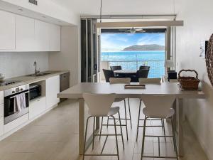 耐莉湾1 Bright Point Apartment 2303的配有桌椅并享有海景的厨房