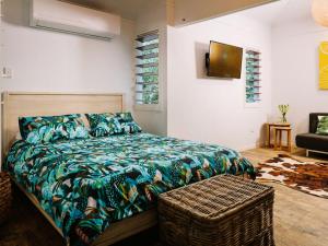 耐莉湾小树丛度假屋的一间卧室配有床和柳条凳