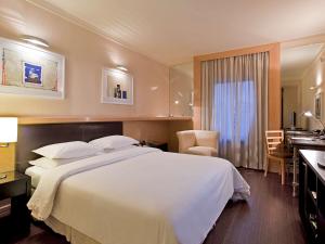 圣保罗铂尔曼圣保罗伊比拉普埃拉酒店的酒店客房设有一张大床和一间浴室。