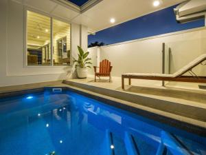 Picnic BayReflections Turquoise Villa 4的房屋设有1个带长凳和椅子的游泳池