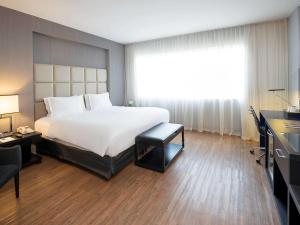 圣保罗圣保罗维拉奥林匹亚铂尔曼酒店的一间设有大床和窗户的酒店客房