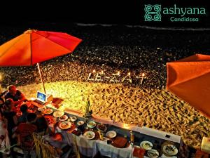 甘地达萨Ashyana Candidasa Beach Resort的一群人坐在餐桌旁,桌上放满了食物