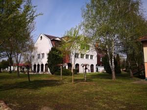 加尔多尼Laguna Panzió的一座大白色房子,在院子里种有树木