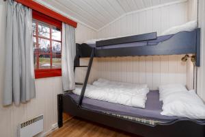 贝特斯托尔克努茨海特格伦德山间小屋的一间卧室设有两张双层床和一扇窗户。