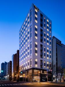札幌Bespoke Hotel Sapporo的城市街道上一座高大的建筑,窗户