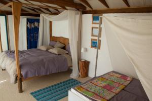 蓬蒂-达巴尔卡Drop-Inn Nature, Relax, Hike and SKATE的一间卧室配有一张床和一张天蓬床