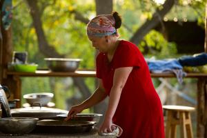 Grigor'yevkaBel-Zhan Yurt Lodge的穿着红色衣服的女人在锅里准备食物