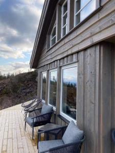 伯Ski in-out at Lifjell-Mountain cabin with majestic views close to Bø Sommarand的一组椅子坐在建筑物的一侧
