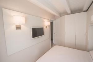 泰穆BILOCALE BELLA VISTA的一间设有床铺和墙上电视的房间