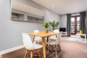 艾尔Elliot Suite No3 - Donnini Apartments的一间带木桌和白色椅子的用餐室