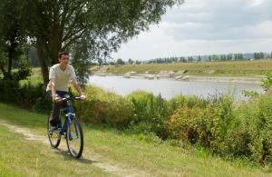 Moidrey曼德黑湾度假酒店的骑着自行车在河边的路上的人