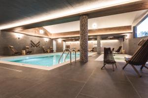 塔特兰斯卡斯特拉ARIETES MARMONT Resort的游泳池位于酒店带椅子的客房内,游泳池