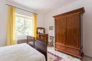 扎费拉纳-埃特内阿At Armando's Home的一间卧室配有一张床和一个木制橱柜