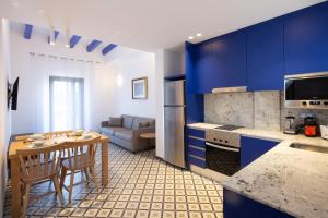 塔拉戈纳Tgna Cervantes 8的厨房配有蓝色橱柜和桌椅