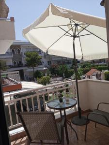 尼亚米卡尼奥纳DESPOINA APARTMENT 3 Relax的阳台配有桌椅和遮阳伞
