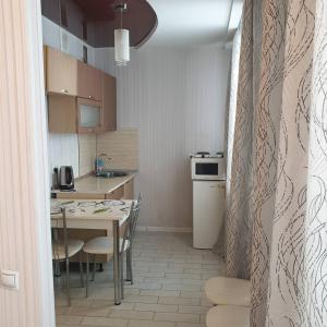 乌里扬诺夫斯克Симбирские апартаменты на Варейкиса 42的一间带桌子的小厨房和一间餐厅