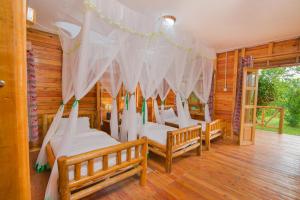 KatunguruEngiri Game Lodge and Campsite的一间设有四张床铺和白色床单的客房