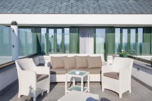 弗尔沙茨布雷格别墅酒店的阳台配有沙发、椅子和桌子