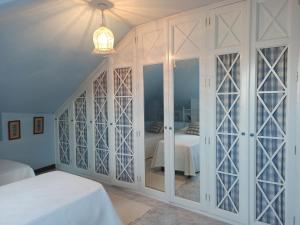 诺哈Duplex céntrico en Noja con acceso a spa relax.的卧室配有带玻璃门的白色壁橱