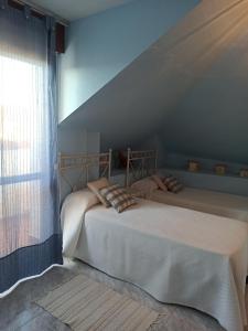 诺哈Duplex céntrico en Noja con acceso a spa relax.的带窗户的客房内的两张床