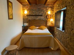 Avín阿尔达酒店的卧室配有一张石墙床
