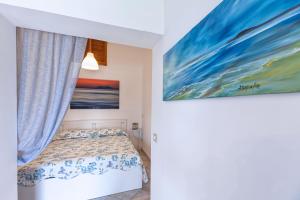 斯佩隆加La stanza di Vali的卧室配有一张床,墙上挂有绘画作品