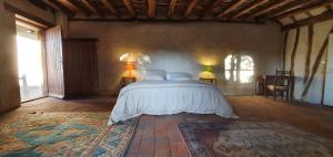 阿姆博斯Aux Ecuries du Signe的一间卧室配有一张带两盏灯和地毯的床。