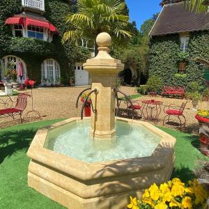 尚蒂伊Manoir des Cavaliers - BnB的房子的院子中的一个石头喷泉