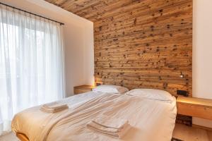 科尔蒂纳丹佩佐Casa del Lupo的一间卧室设有一张床和木墙