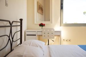 阿特米达艾菲公寓的一间卧室配有一张床和一张带花瓶的书桌