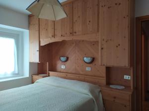 罗卡皮耶托雷Residence Marmolada的一间卧室配有一张木墙床