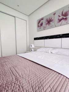 贝尼多姆GEMELOS Levante beach apartments的一间卧室配有一张带粉色毯子的大床