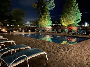 南雅茅斯艾斯凯普茵酒店的夜间游泳池,配有椅子和灯