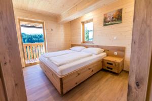 兹雷切Apartmaji na kozolcu - Smogavc的木制客房的一张床位,设有窗户