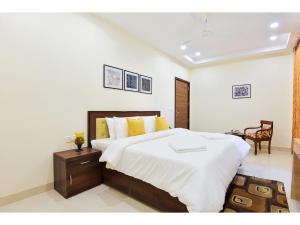 古尔冈BluO Studio5 Golf Course Road - Gym, Terrace Garden的一间卧室配有一张带白色床单和黄色枕头的大床。